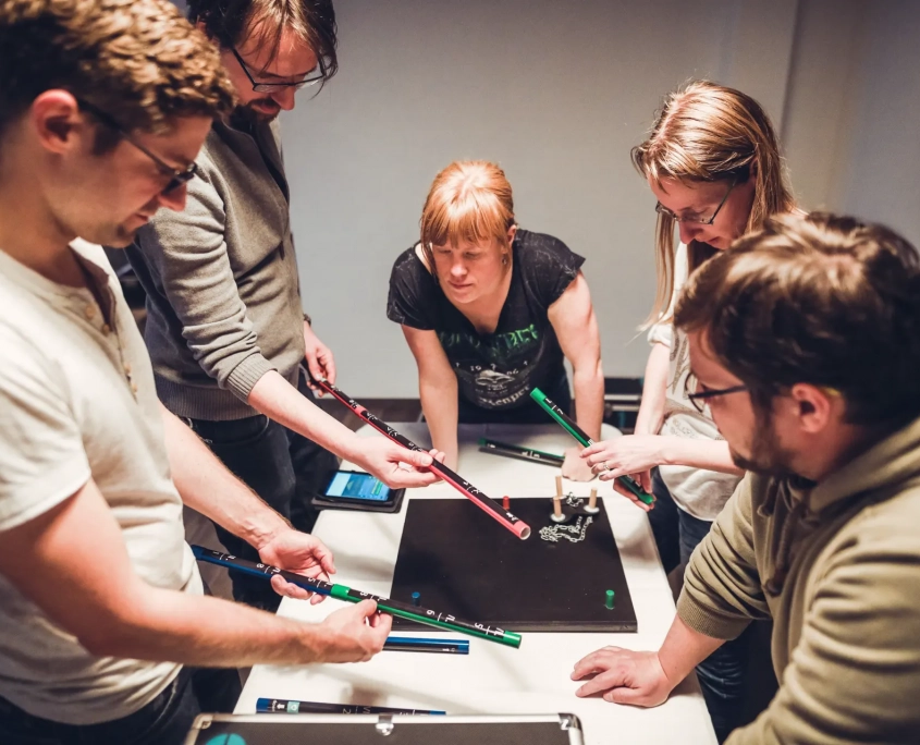 Fortnoxx Rätsel Eine Gruppe löst gemeinsam Rätsel am Tisch