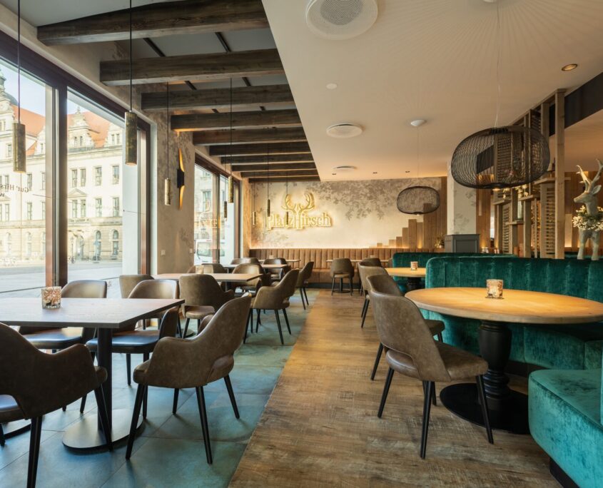 Innere des stilvoll eingerichteten Restaurants Platzhirsch, moderne und gemütliche Einrichtung aus Holz- und Samtelementen.