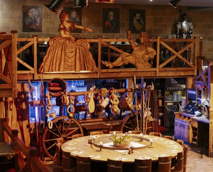 Restaurant Sophienkeller, Tische und Stühle aus Holz mit geschmückten Holzfiguren