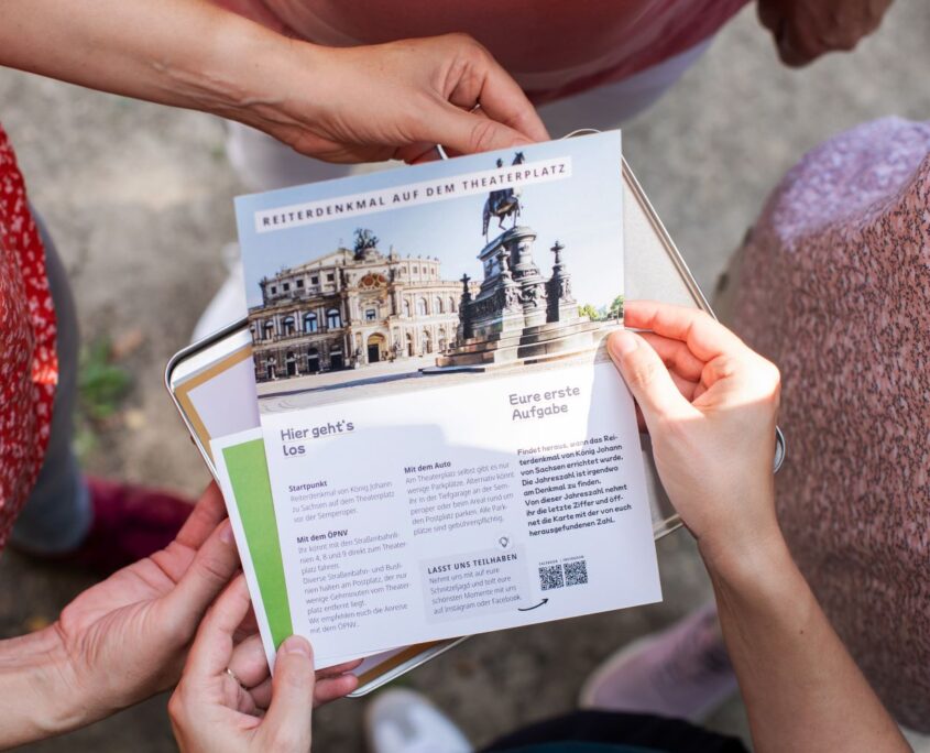 Stadtspiel Schnitzeljagd Dresden, Spieler halten Aufgabenblatt in der Hand